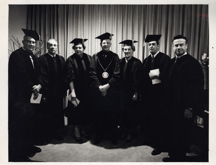 Dorothy Stolzenbach Payne and others at a ceremony in a commencment gown.